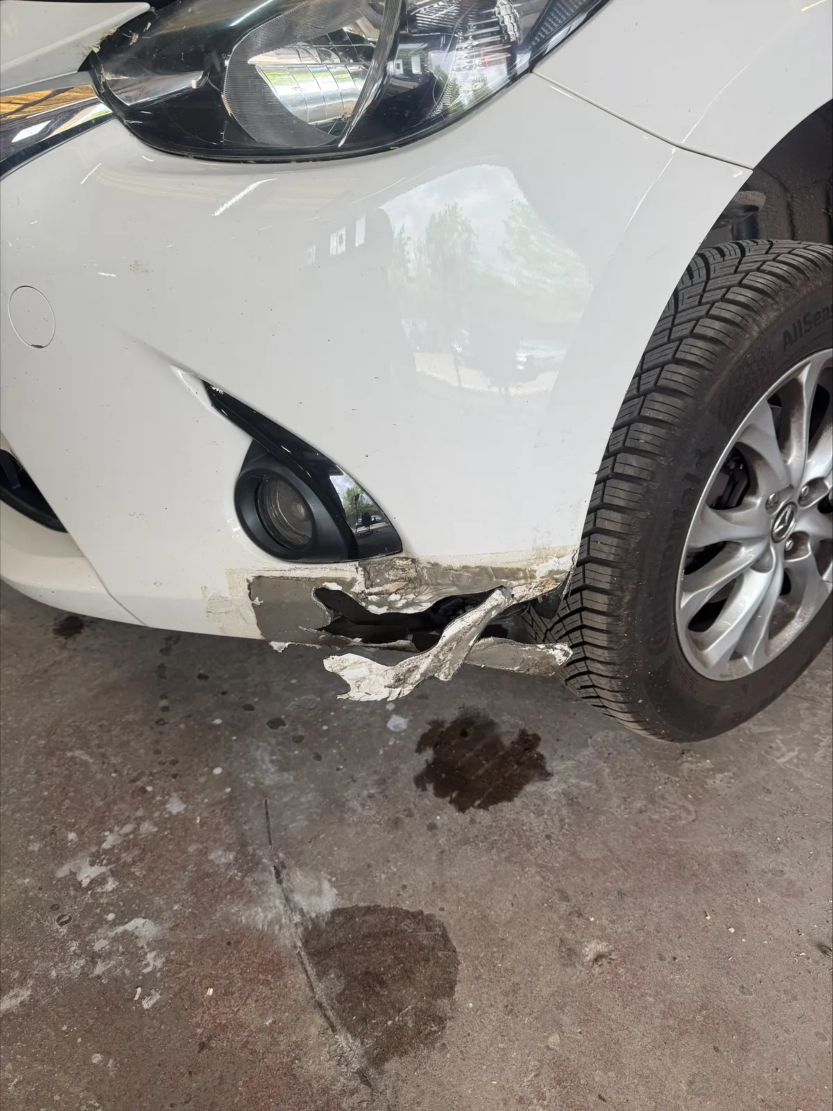 Damaged front bumper corner before repair